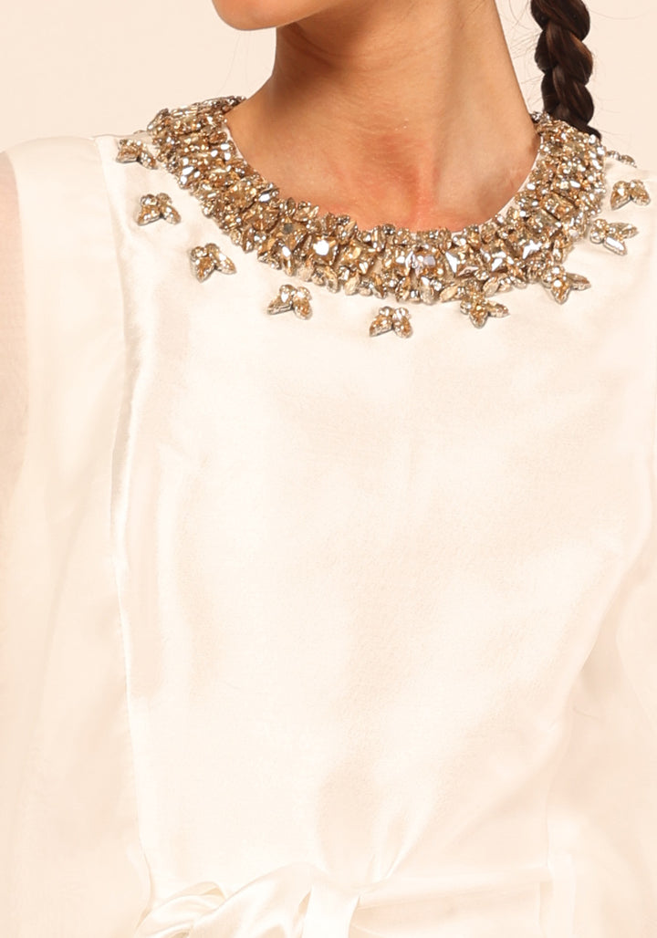 Close view of the Almas Kaftan in white, showing the diamond effect studs set around the round neckline, by Baruni