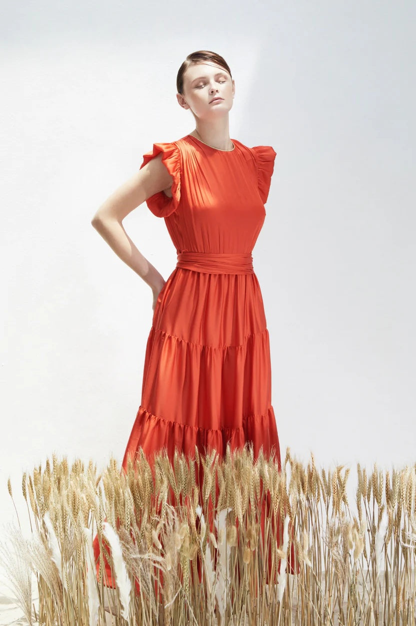 Woman in a red dress standing in a field of wheat 