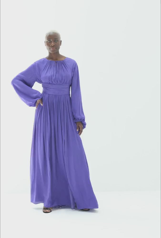 Video of the Aberash Dress in purple blue, showing the gathered sleeves and the side slit in movement as the model walks, by Baruni